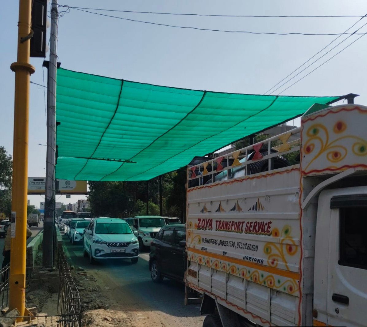 To protect passersby from the intense heat, the municipal corporation installed a green net at the Navayug Market traffic light in Ghaziabad. IMAGE CREDIT TO नगर निगम